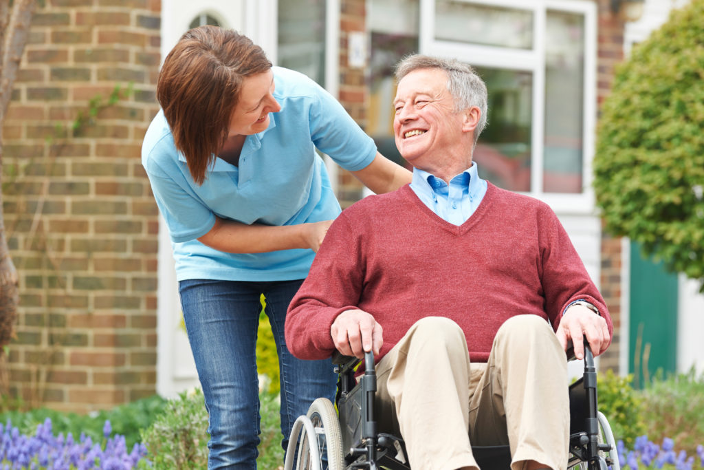 Carer With Senior Man In Wheelchair